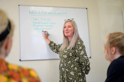 a person writing on a white board