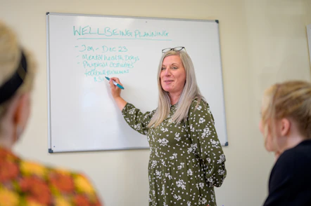 a person writing on a white board