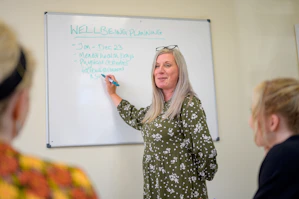 a person writing on a white board