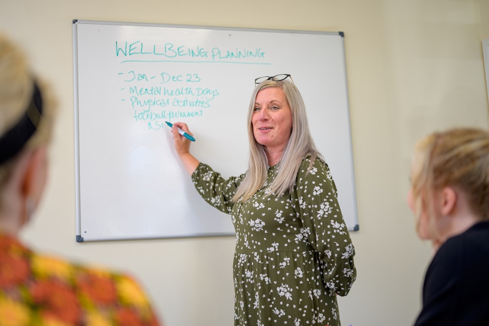 a person writing on a white board