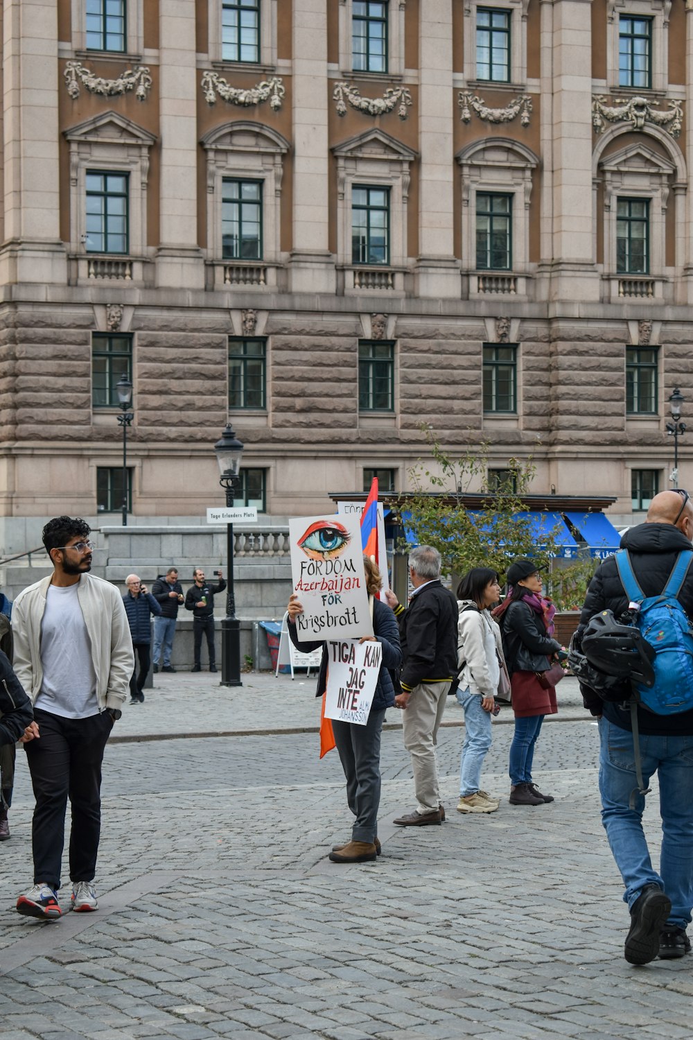 a group of people holding signs in front of a building