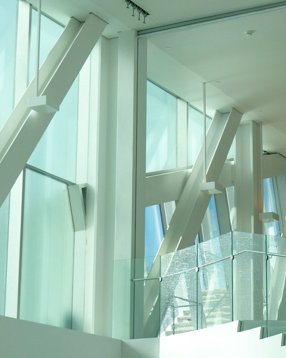 a white staircase with glass railings