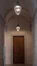 Hallway with antique lanterns and wooden floors leading to the guest rooms.