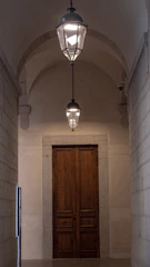 Hallway with antique lanterns and wooden floors leading to the guest rooms.