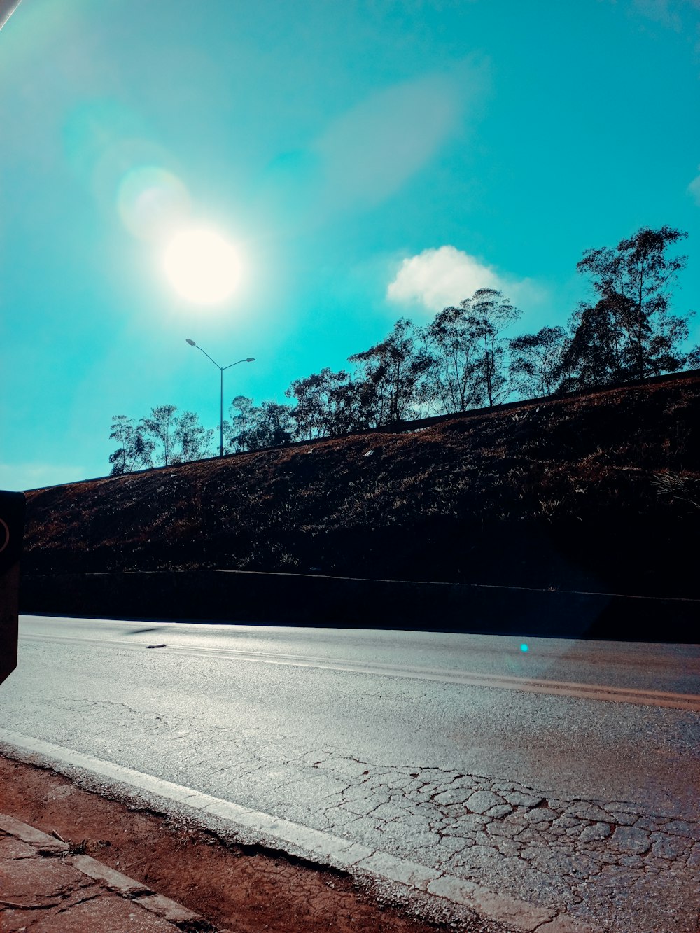 a road with a hill and trees