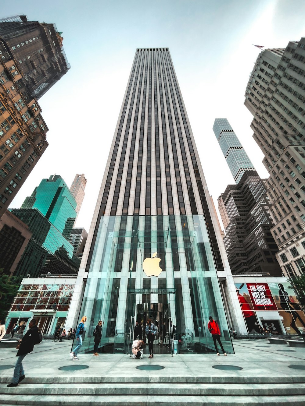 a large glass building with people walking around