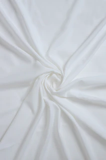 Soft ivory silk fabric draped gracefully with delicate shadows