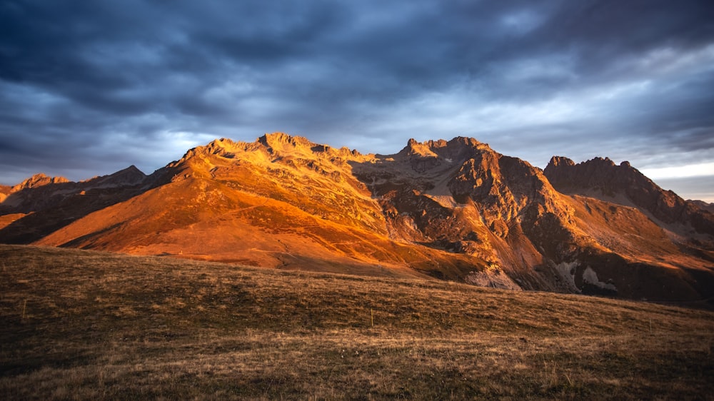 a large mountain with a cloudy sky