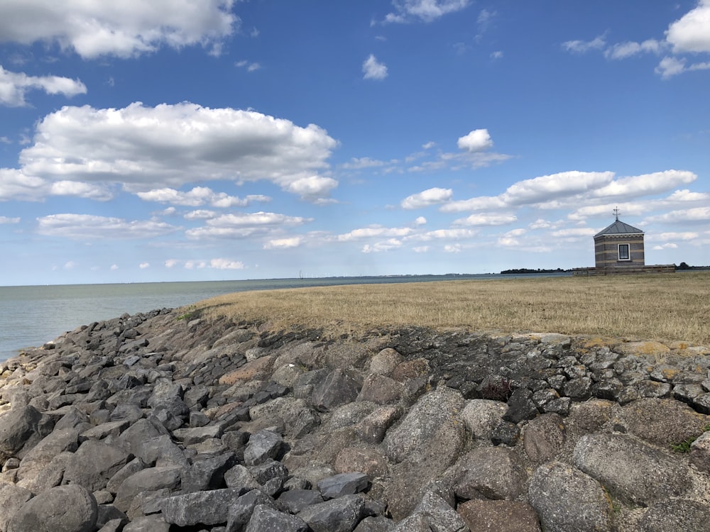 a rocky beach with a building in the distance