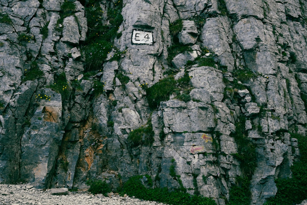 a rocky cliff with a sign on it