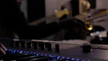 Guitar and keyboard set up ready for a session under soft studio lighting.