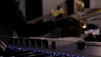 A futuristic studio setup with glowing instruments and digital sound waves surrounding a focused musician.