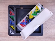 A labeled drawer system with compartments for puzzle pieces and card games.