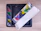 Close-up of hands unboxing a colorful mosaic product with a bright smile in the background.