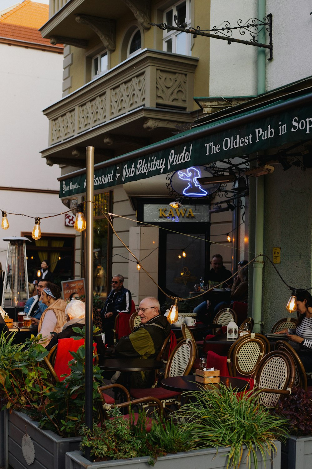 a group of people sitting outside a restaurant