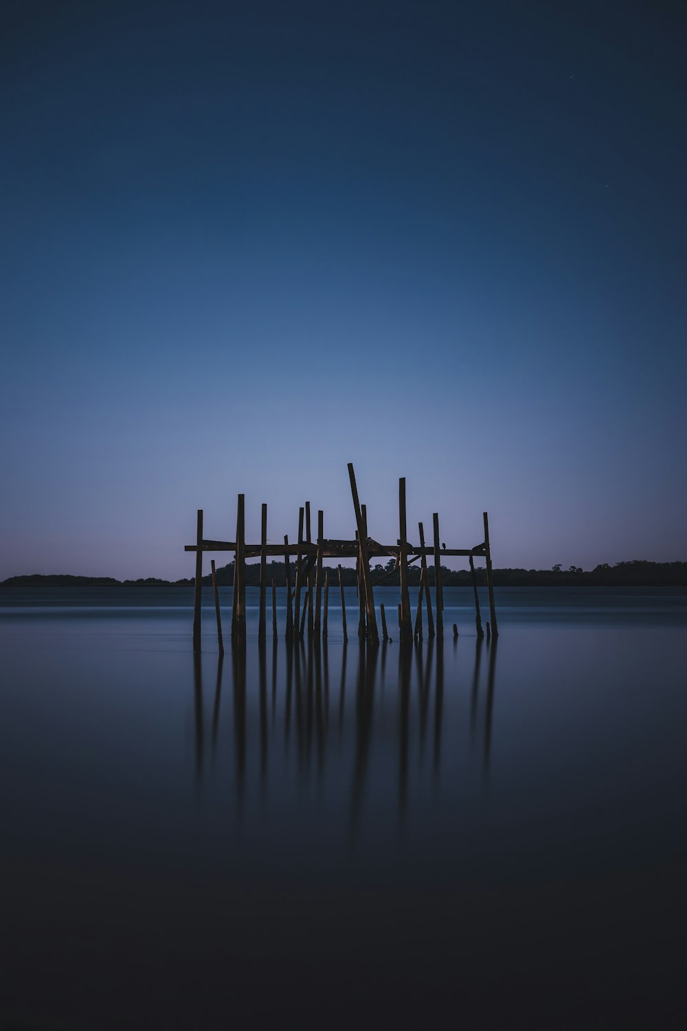 a group of wooden poles in a body of water