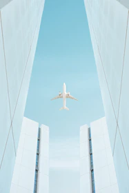 a plane flying between tall buildings