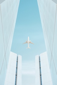 a plane flying between tall buildings