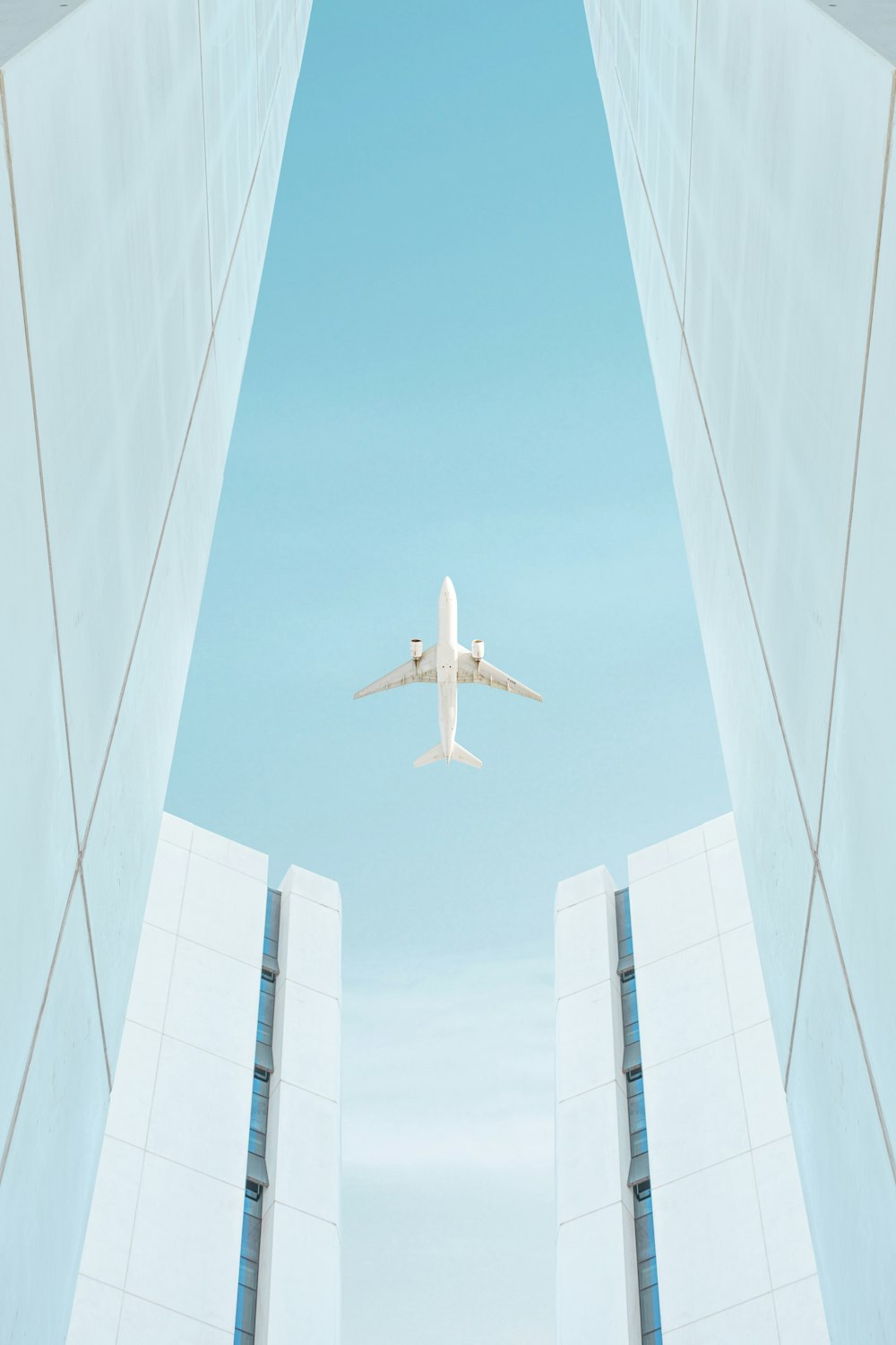 a plane flying between tall buildings