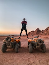 a man standing on two vehicles