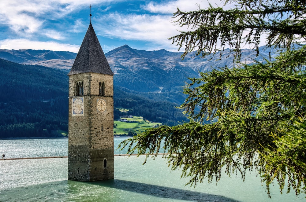 a clock tower next to a lake