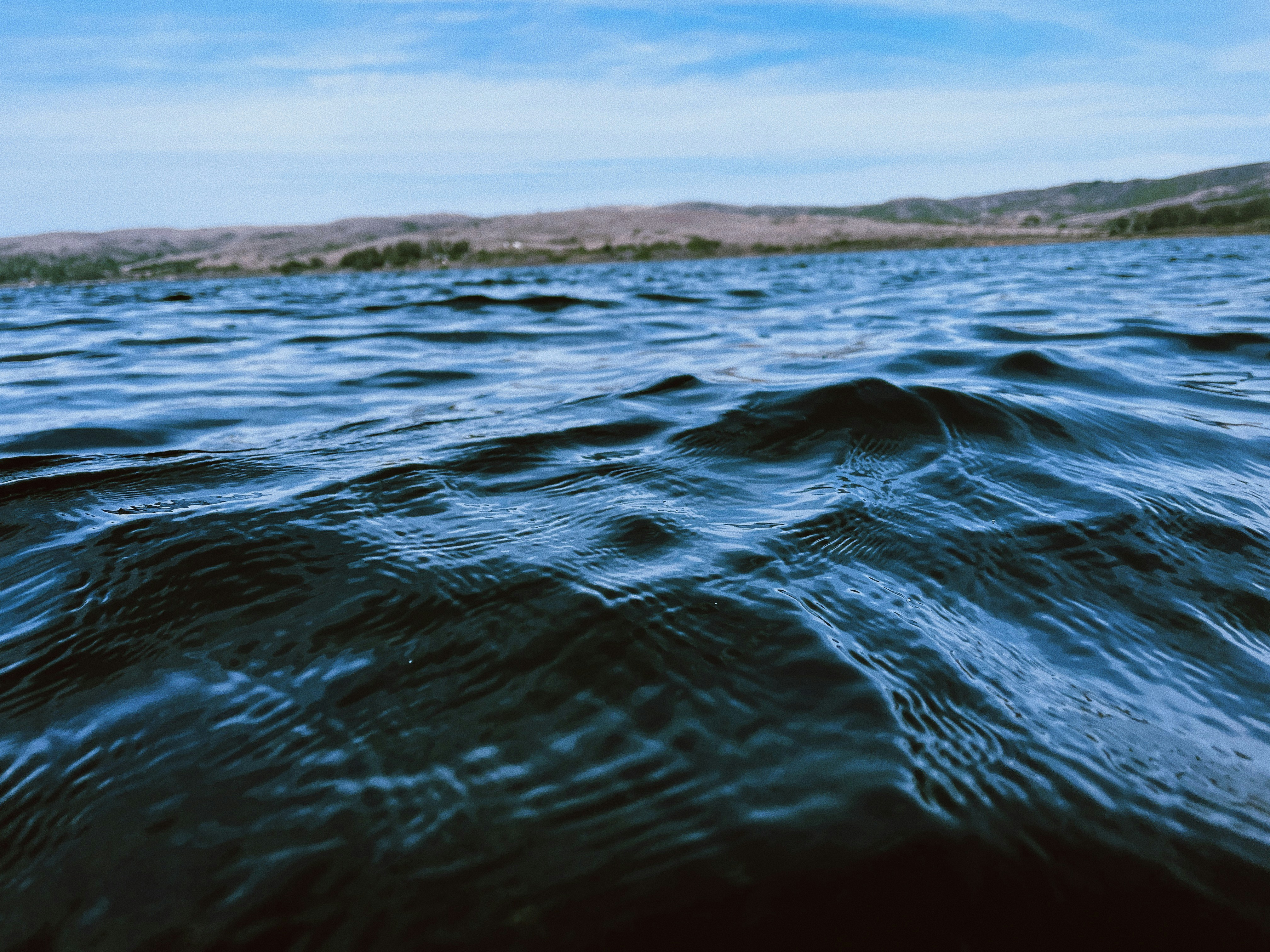 a body of water with rocks and land in the background