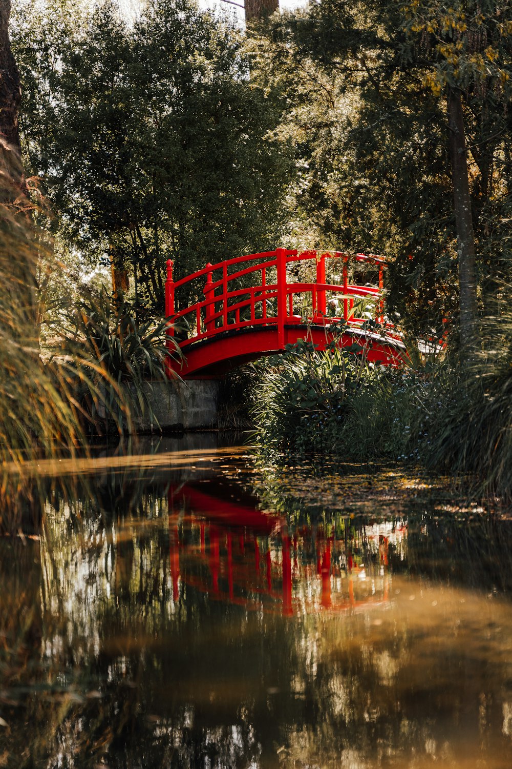 a red bridge over a river