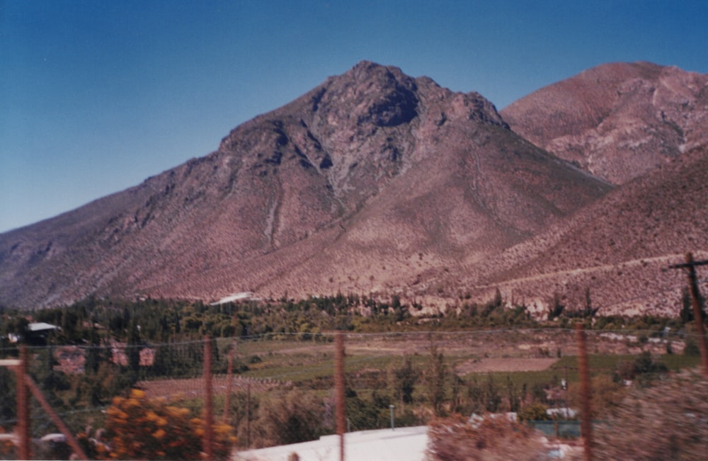 a large mountain with trees and a road below