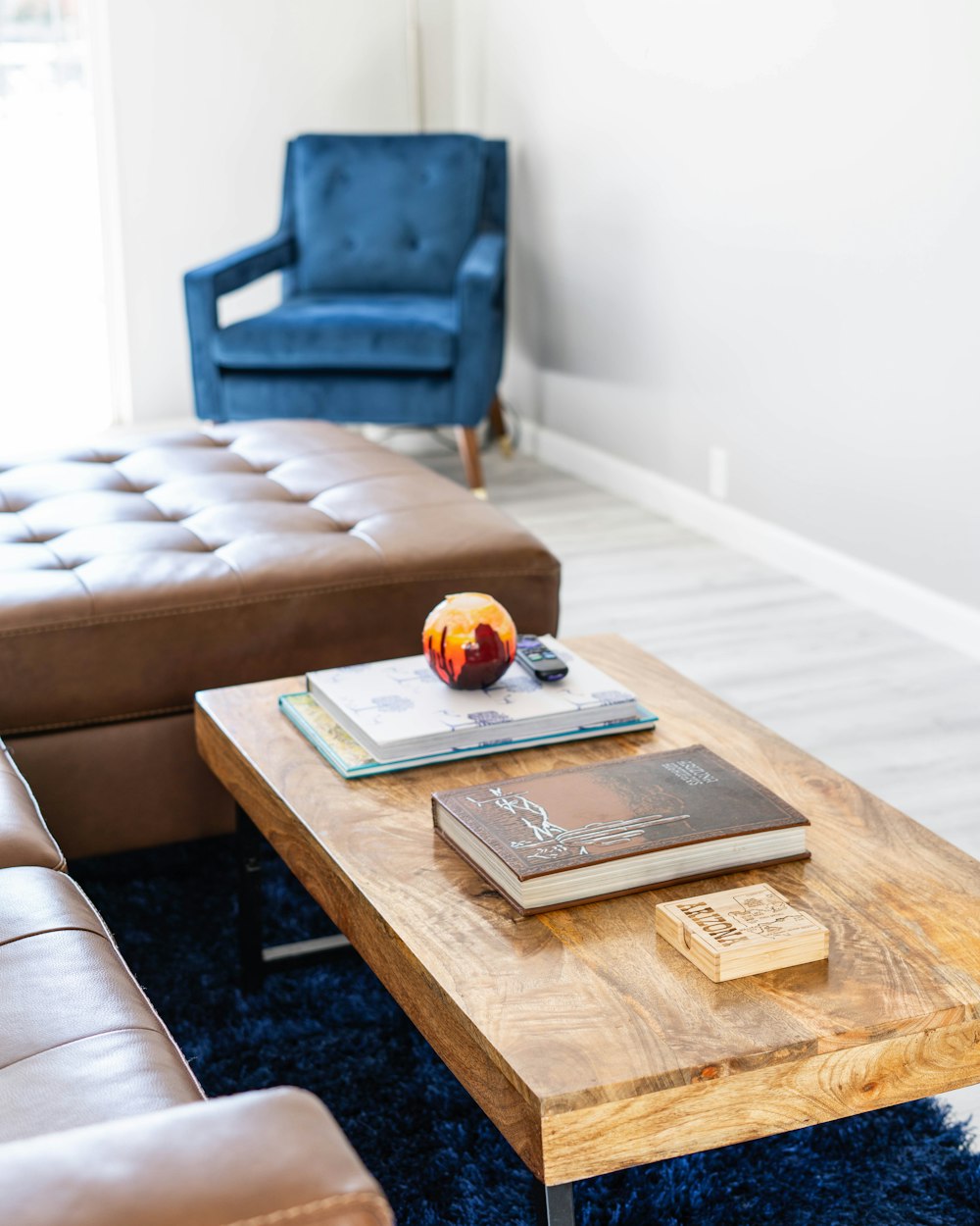 a coffee table with a book and a chair in the background