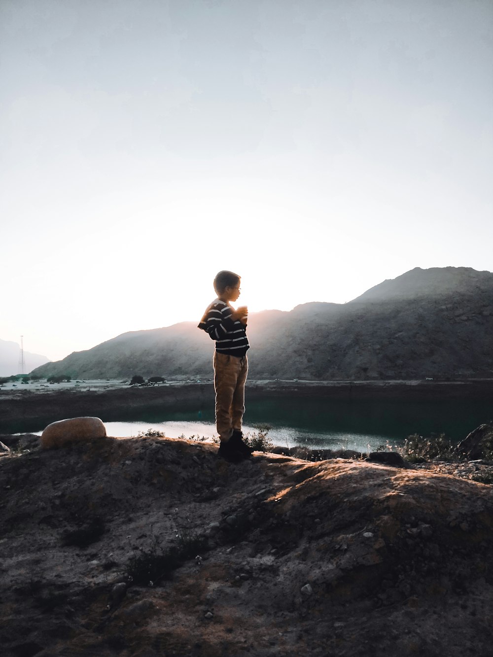 a boy standing on a rock