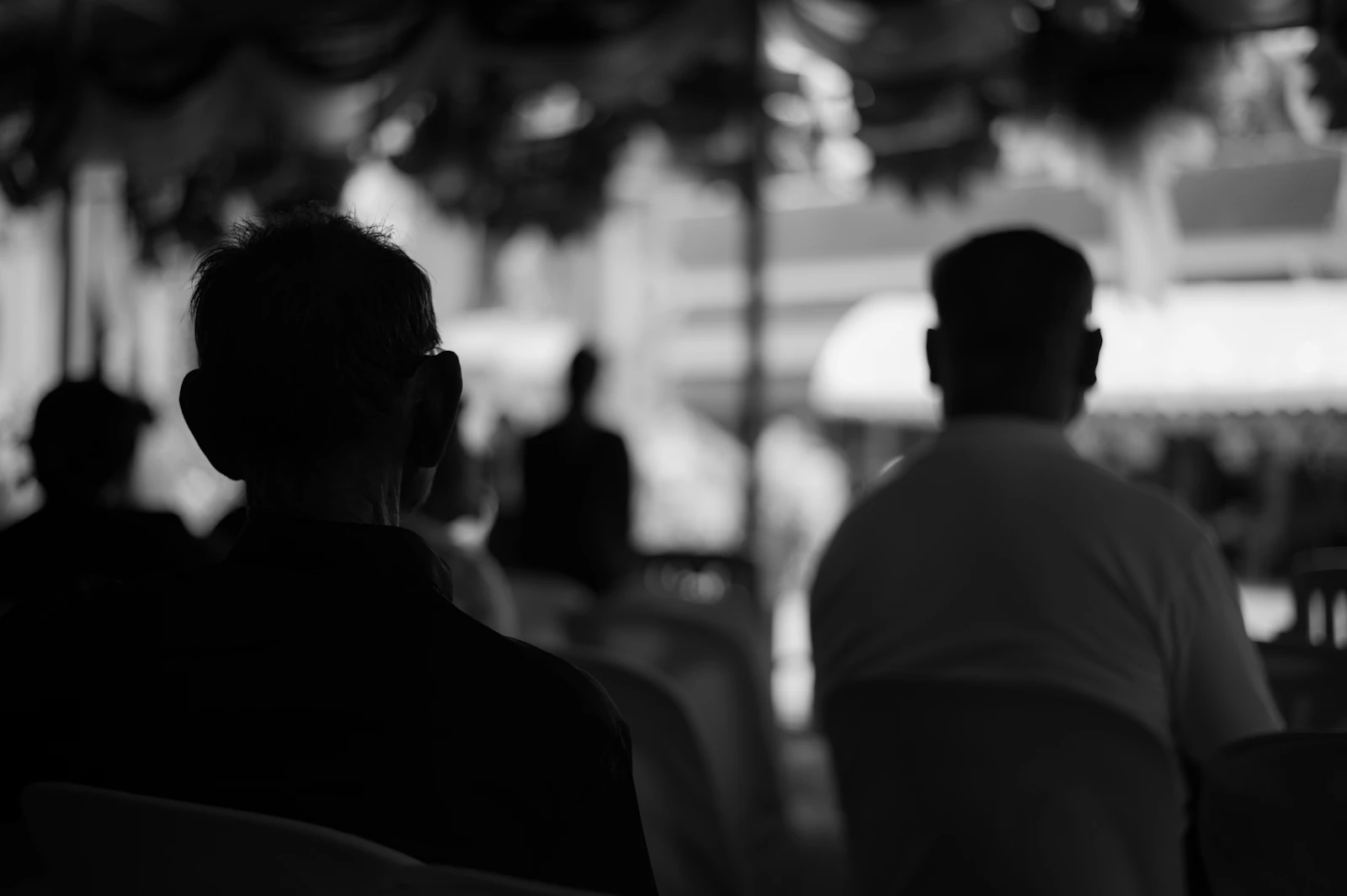A group of people seated in a meeting room, seen in silhouette