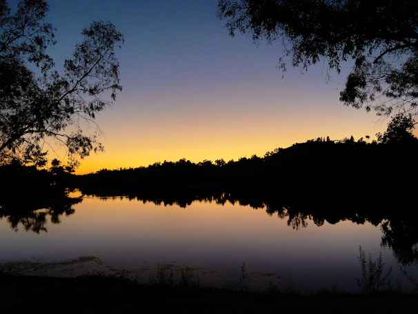 Sunset view over a peaceful lake near the rural homestead.