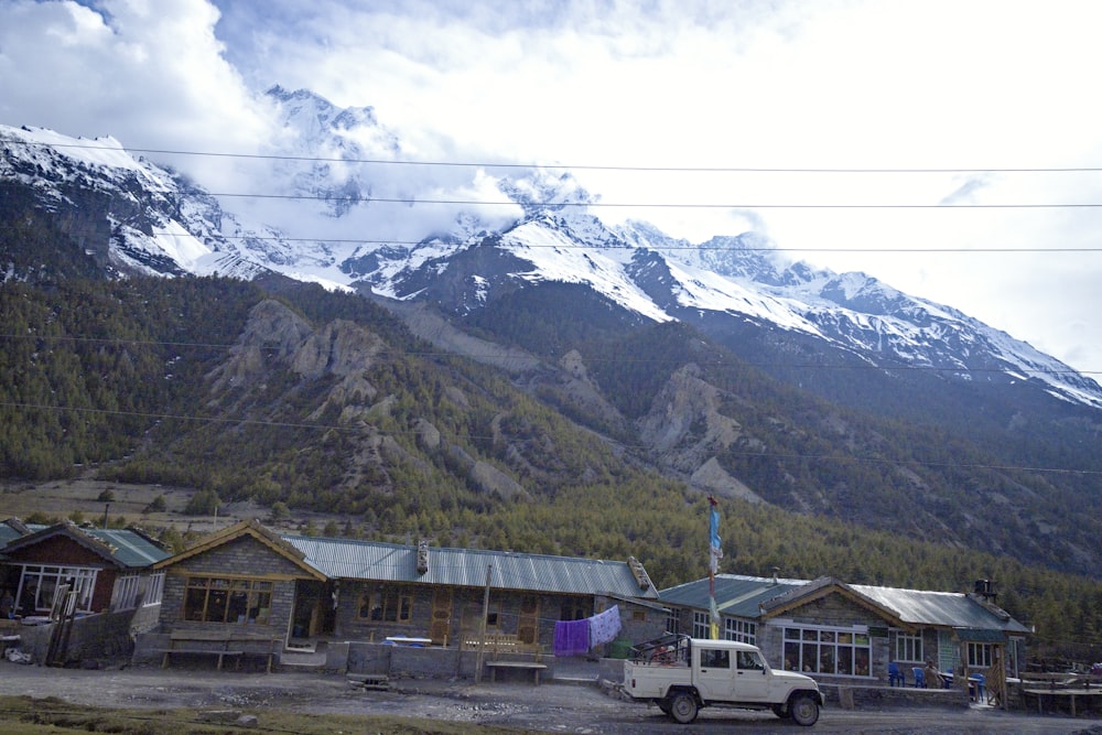 a truck parked in front of a building with mountains in the background