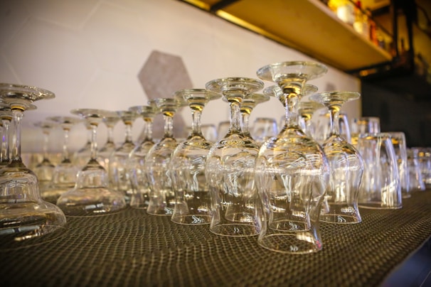 Clear drinking glasses with unique custom designs displayed neatly.