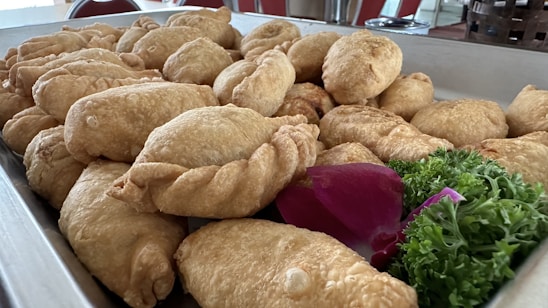 A vibrant close-up of a freshly baked empanada with a golden crust and colorful filling.