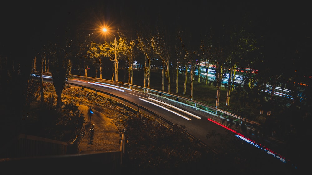 a road with trees and lights at night