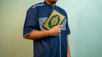 a man wearing a blue shirt and holding a book