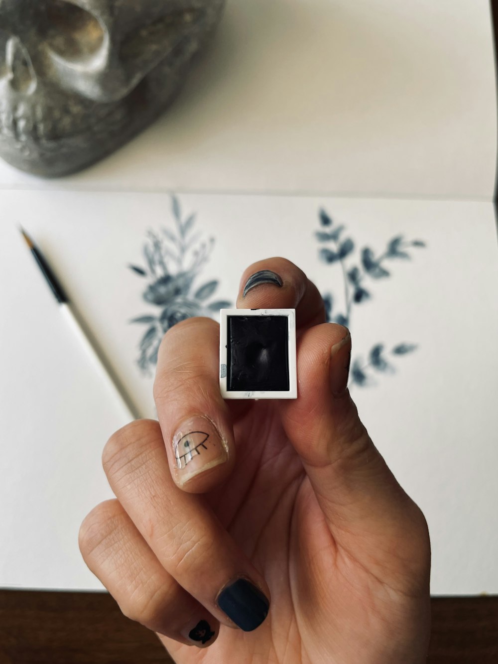 a hand with painted fingernails