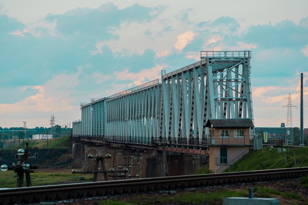 uma linha de trem com uma ponte ao fundo