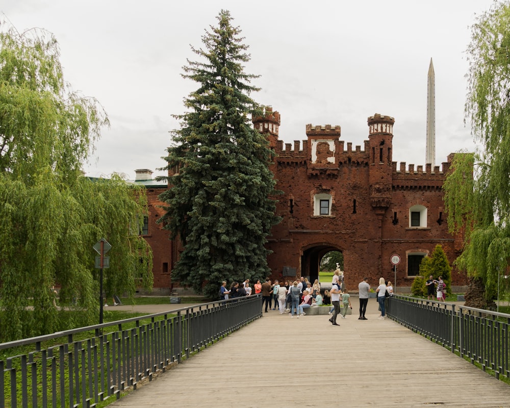 a group of people walking on a bridge in front of a building