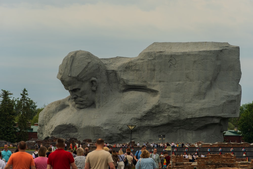 a large stone sculpture of a man with a beard and mustache with Crazy Horse Memorial in the background