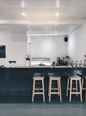 Minimalist coffee bar counter with warm beige tones and clean lines.