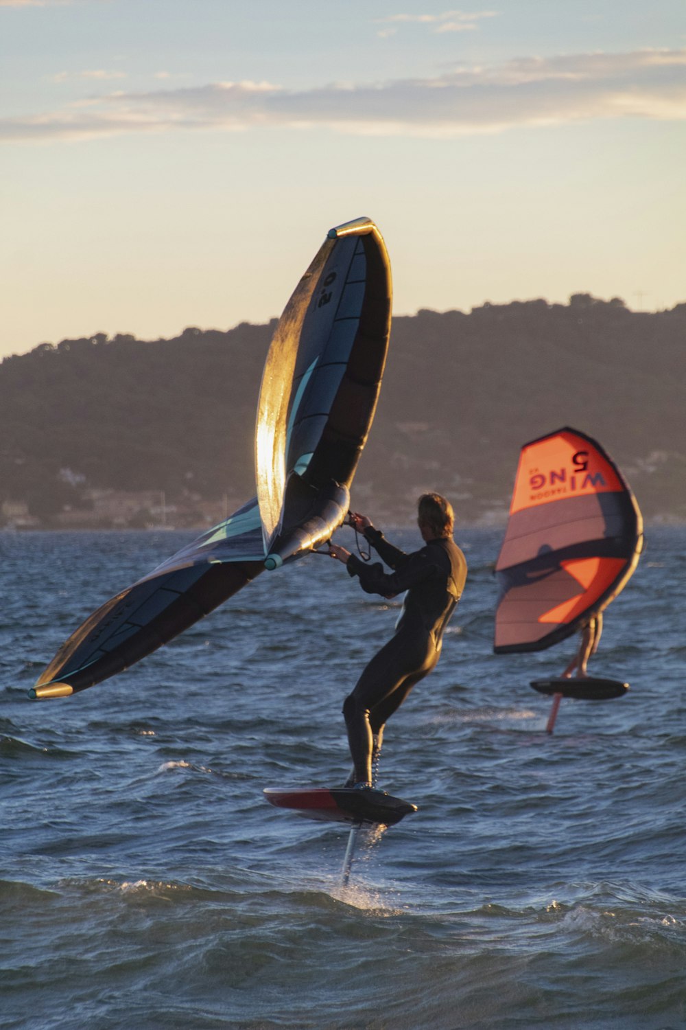 a man on a surfboard holding a sail