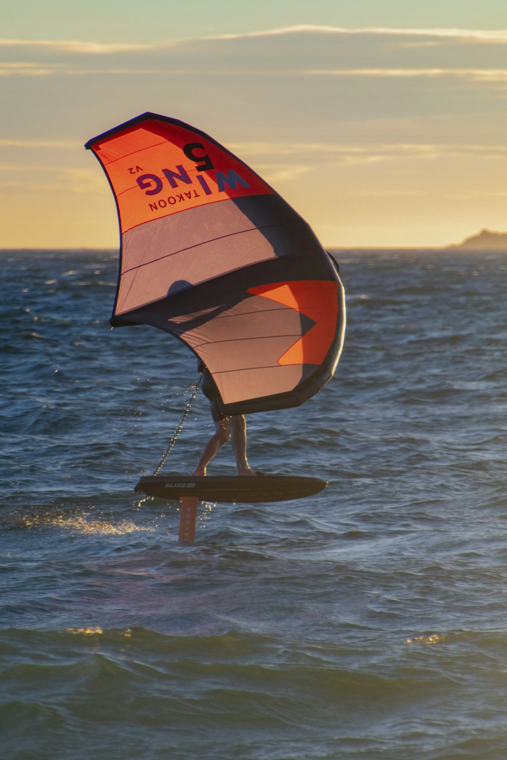 a person on a surfboard holding a sail