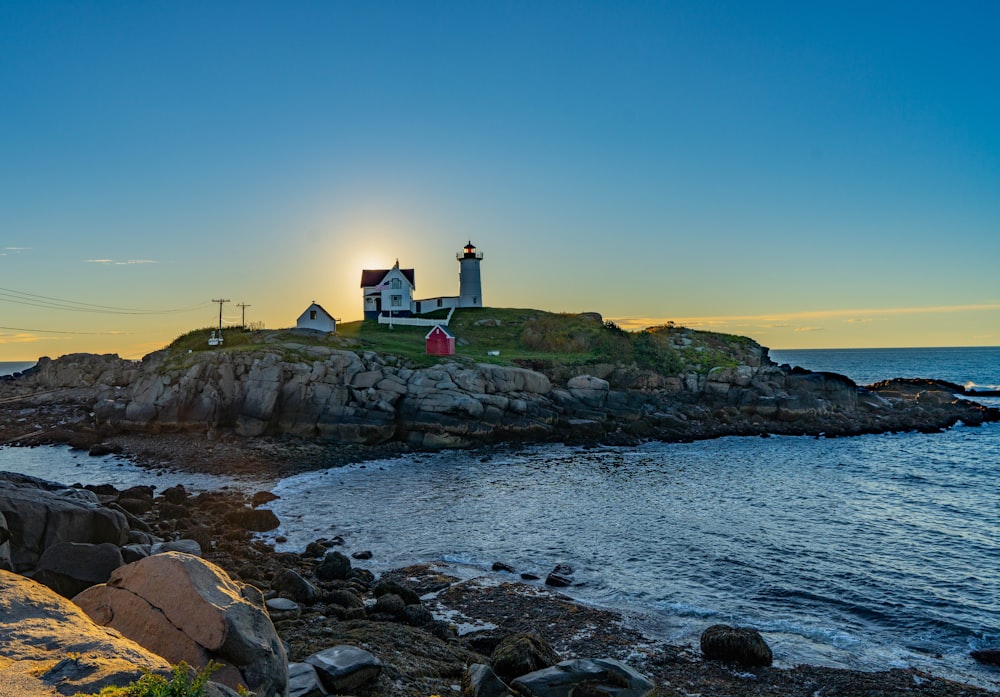 a lighthouse on a rocky island with Cape Neddick Light in the background