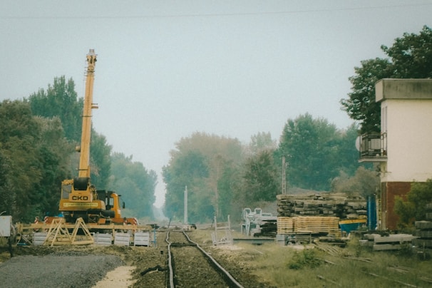 Engineers inspecting a complex railway infrastructure site with cranes and tracks stretching into the distance.