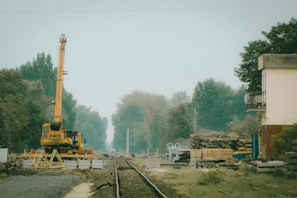 A busy railway project site showing tracks being laid with heavy machinery.