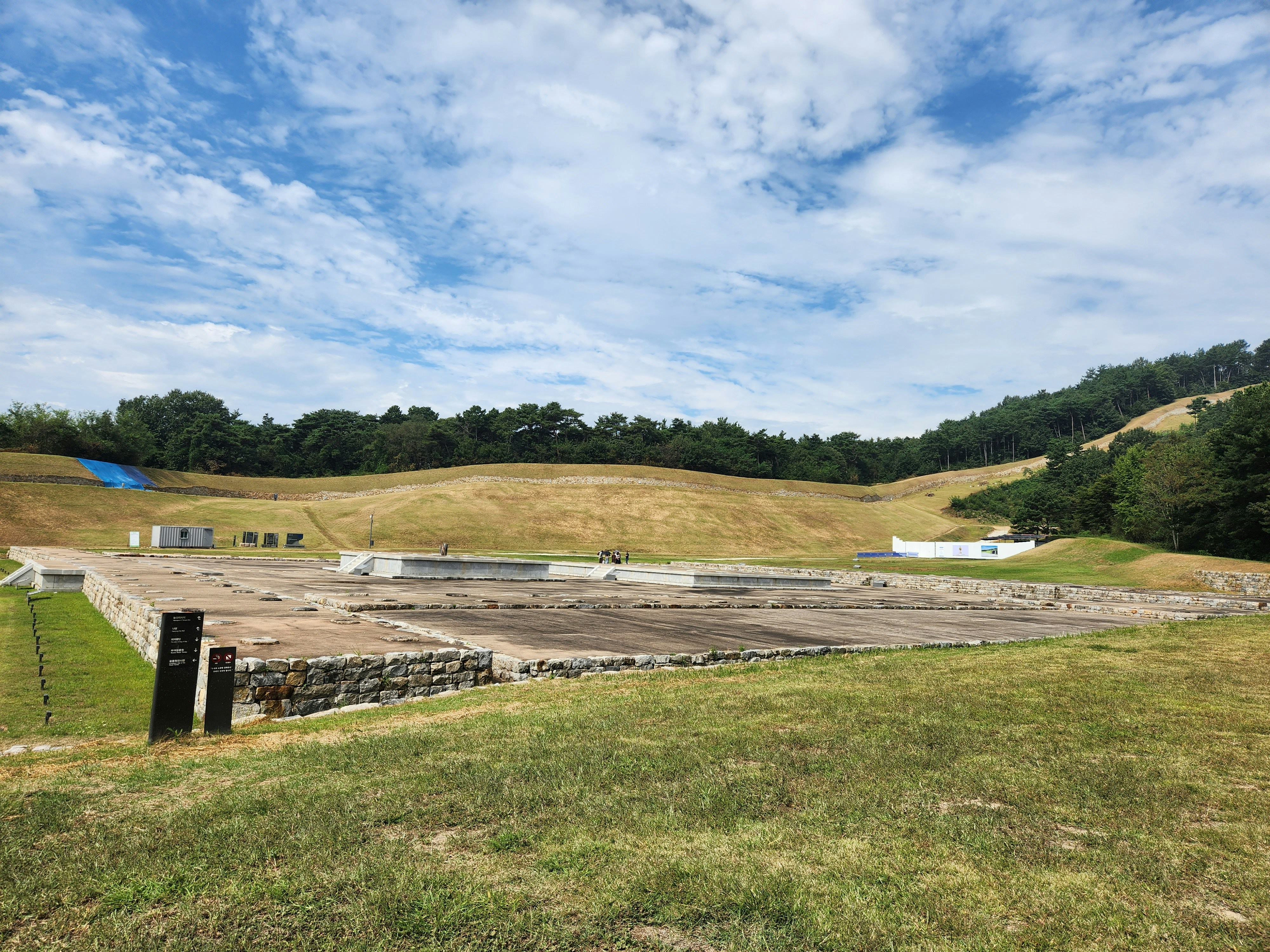 Ancient stone foundations sit within an expansive archaeological park.