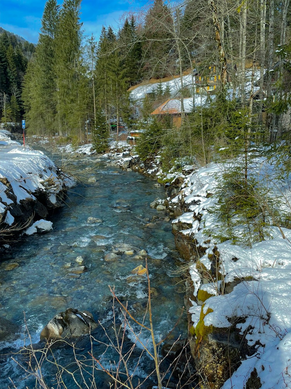 Ein Fluss mit Schnee und Bäumen