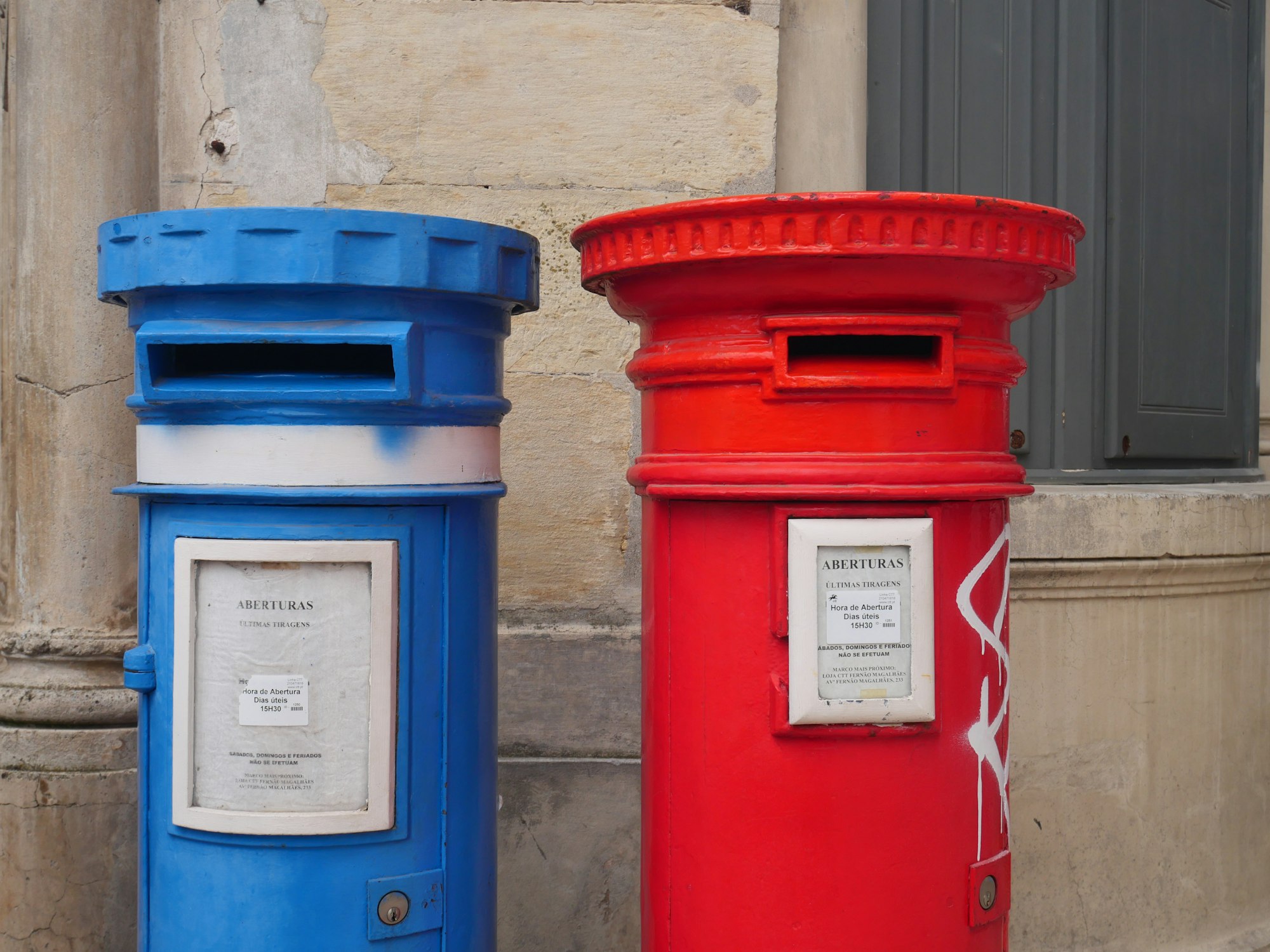 A blue and red mail box next to each other